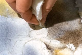 A hand fixing the mistakes of the watercolour fire picture