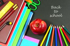 Back to school concept with stacked books red apple school supplies and color pencils
