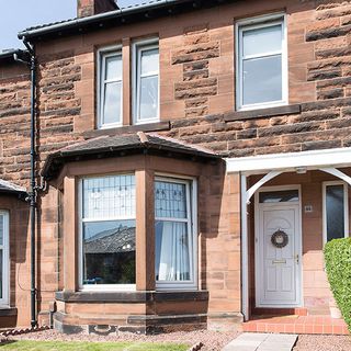 house exterior with stone brick wall and large window