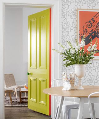 Door open between dining and living room, chatreuse painted door, wallpaper and coral accents