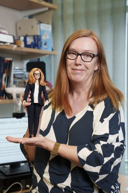 Professor Sarah Gilbert posing with her Barbie doll