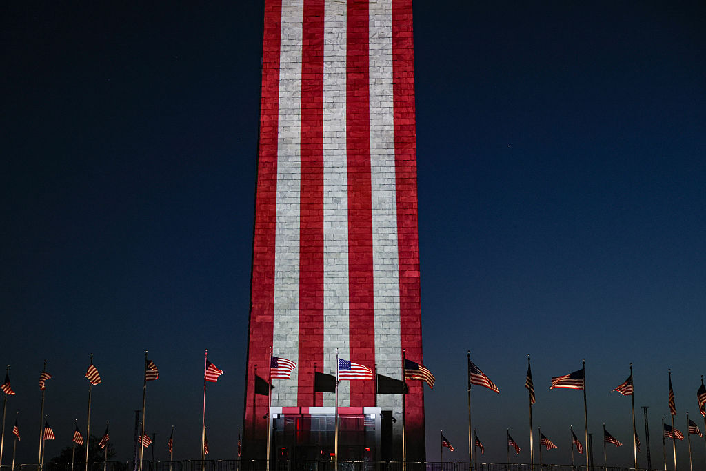 O Monumento a Washington iluminado em vermelho, branco e azul