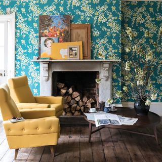 sitting area with yellow armchair and floral wallpaper wall and fireplace