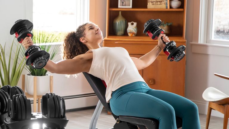 Woman exercising with the Bowflex SelectTech 552 adjustable dumbbells