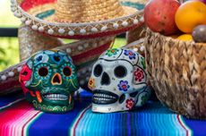 Two Mexican skulls, sombrero hat and basket of fruit