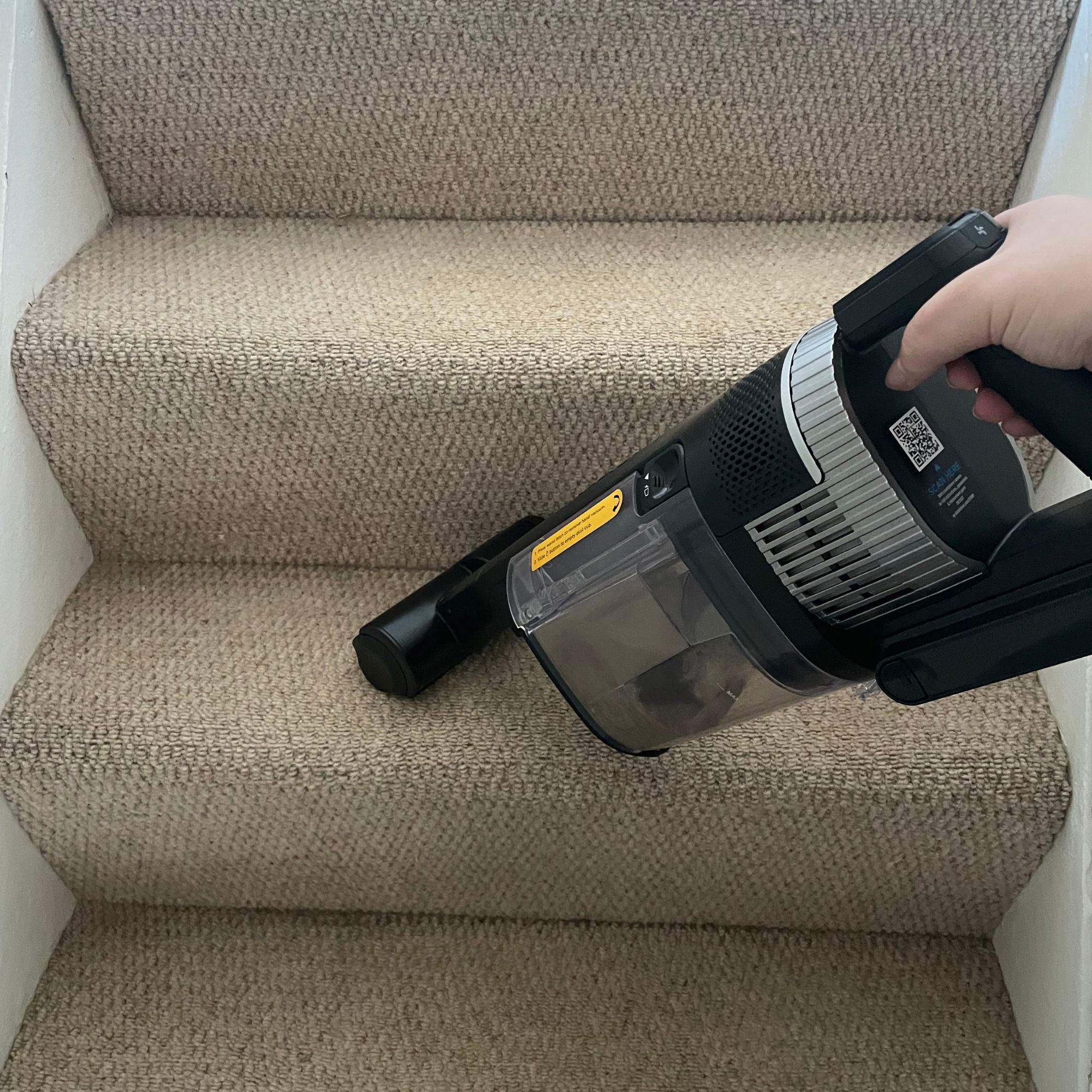 Shark Stratos Cordless Vacuum being used to clean carpeted stairs