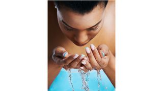 A woman washing her face with water