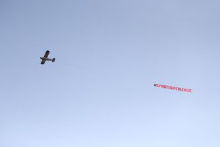 A plane carries a banner protesting against the European Super League