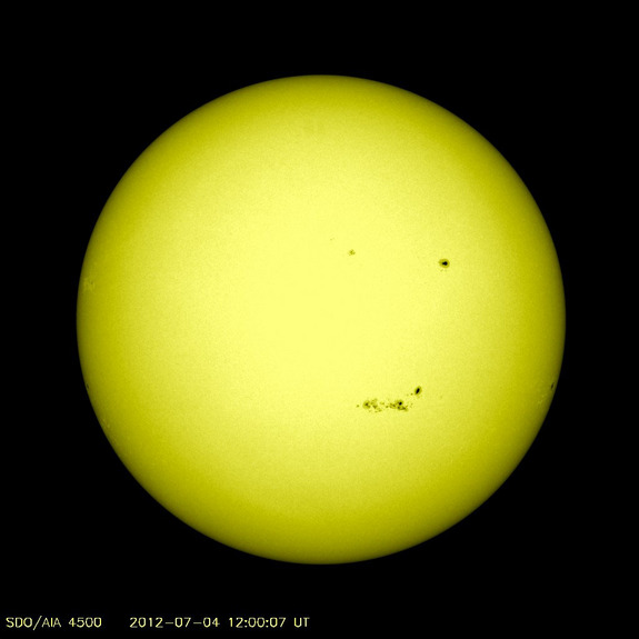 This visible light image of the sun on July 4, 2012, shows the location of several sunspot patches on the sun's surface. The large sunspot group on the bottom of the sun is sunspot AR1515, an active region 100,000 km long. NASA's Solar Dynamics Observatory provided this view.