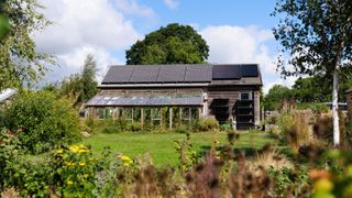 exterior of eco home with solar panels, conservatory and large garden