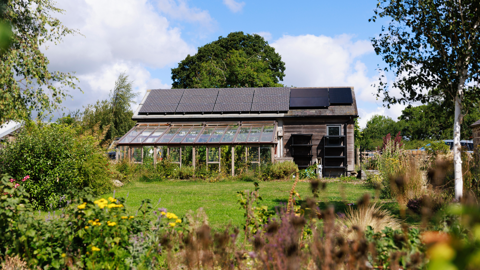 exterior of eco home with solar panels, conservatory and large garden