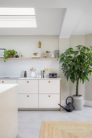 White wooden kitchen with poured concrete floor