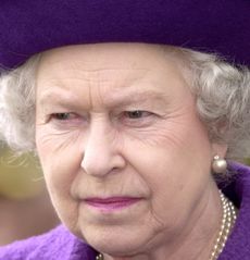 Queen Elizabeth wearing a purple hat and coat and looking angry