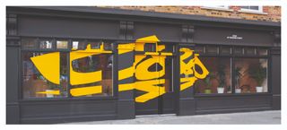 Black building frontage with stylish yellow lettering