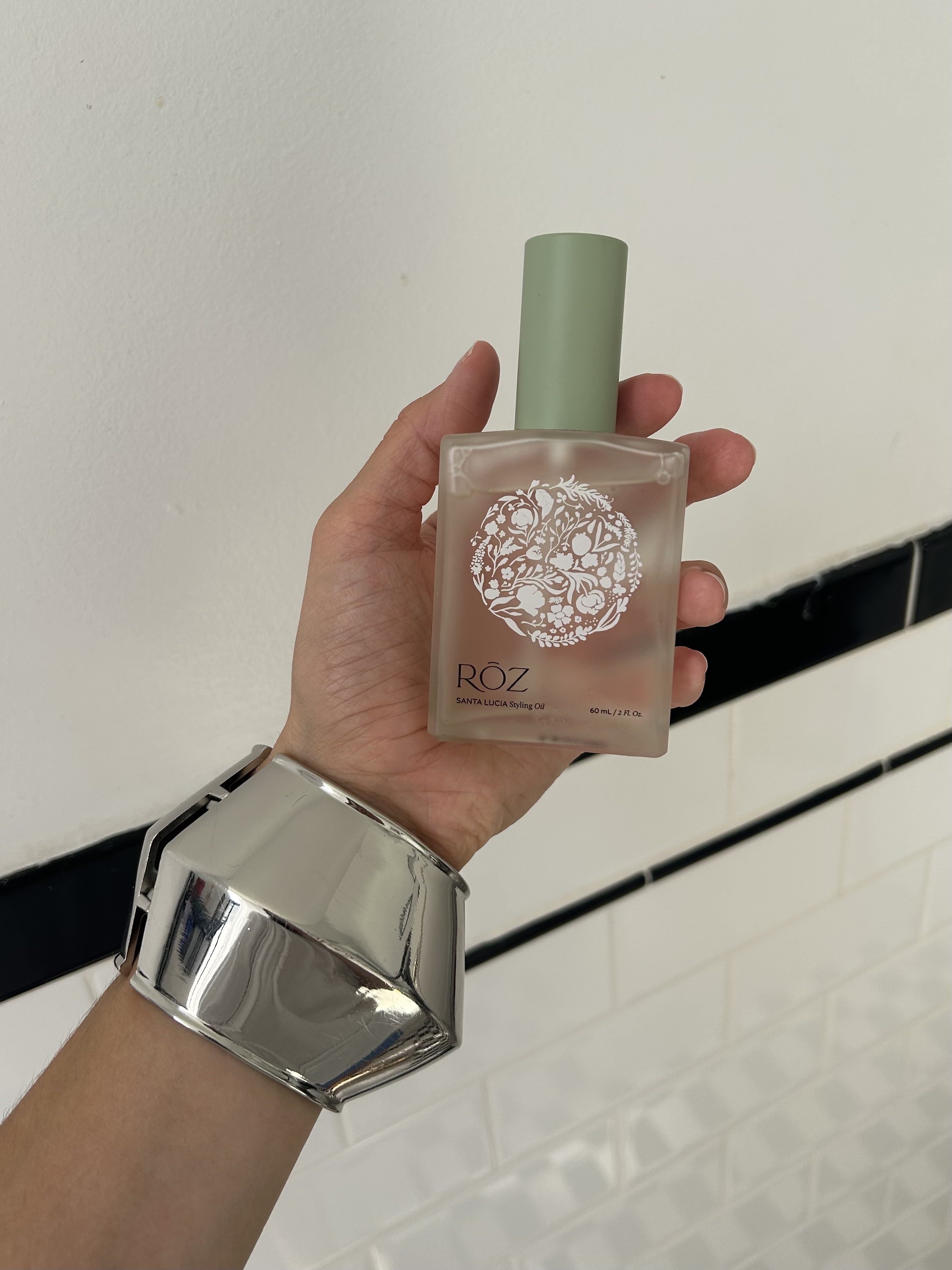Alyssa Brascia holding the Rōz Santa Lucia Styling Hair Oil.