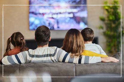 back view of family watching tv at home