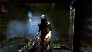 En skärmdump från ett Amnesia-spel, där en mörk varelse går mot spelaren i ett mörkt rum.