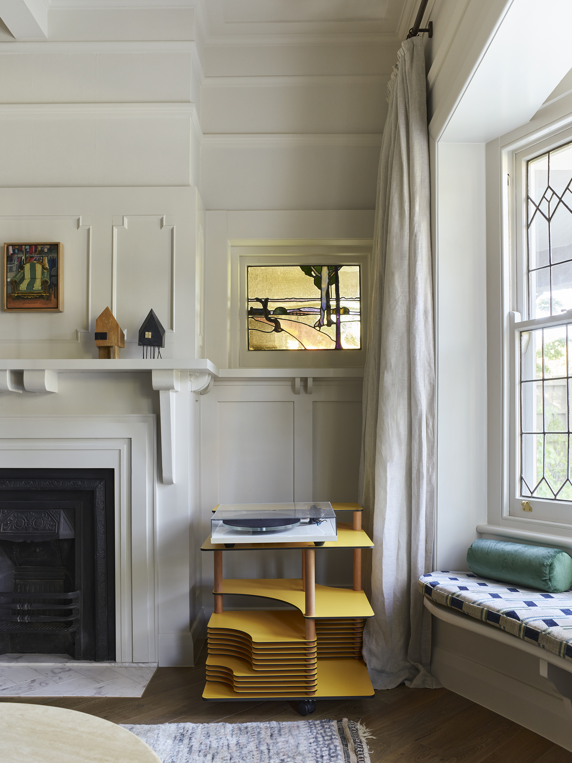 living room with heritage features, wall molding, fireplace, freestanding record player unit, window seat and stained glass windows