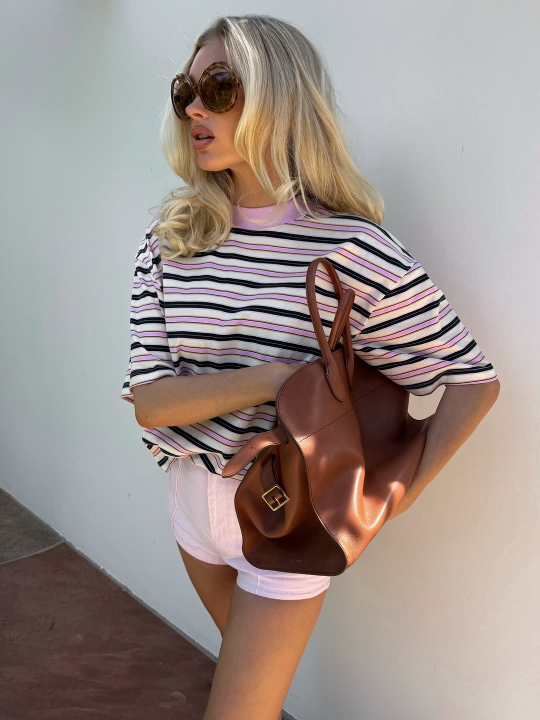 Model Elsa Hosk wears a striped t-shirt with pink shorts.