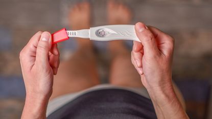 Woman holding pregnancy test