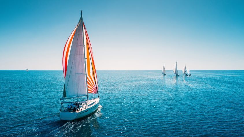 Sailing boat at sea with other boats in the distance