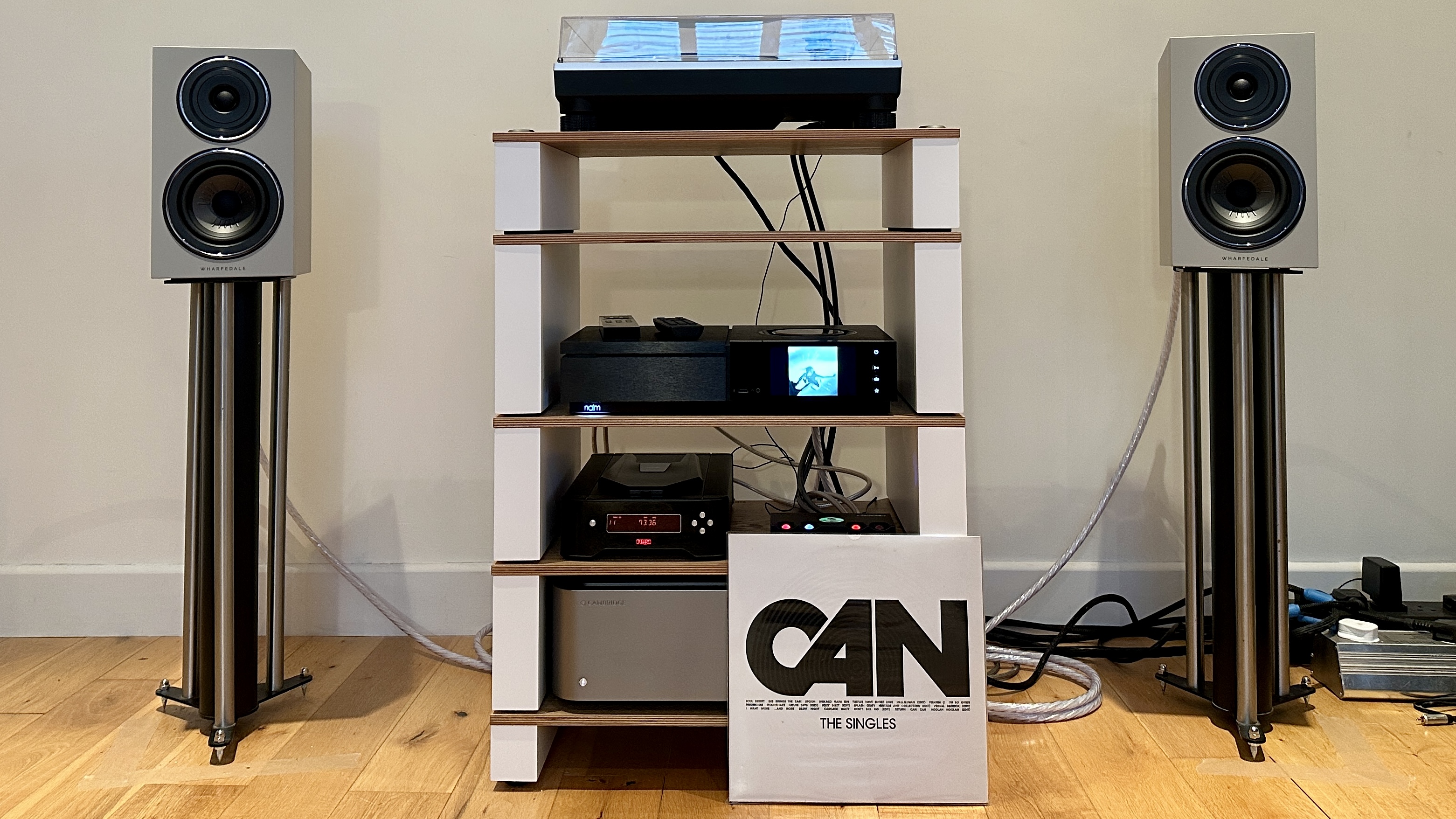 The Wharfedale Diamond 12.1i speakers on stands, on either side of a hi-fi setup with a Naim amp, plus a turntable and CD player