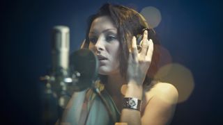 Woman sings into a microphone in the studio