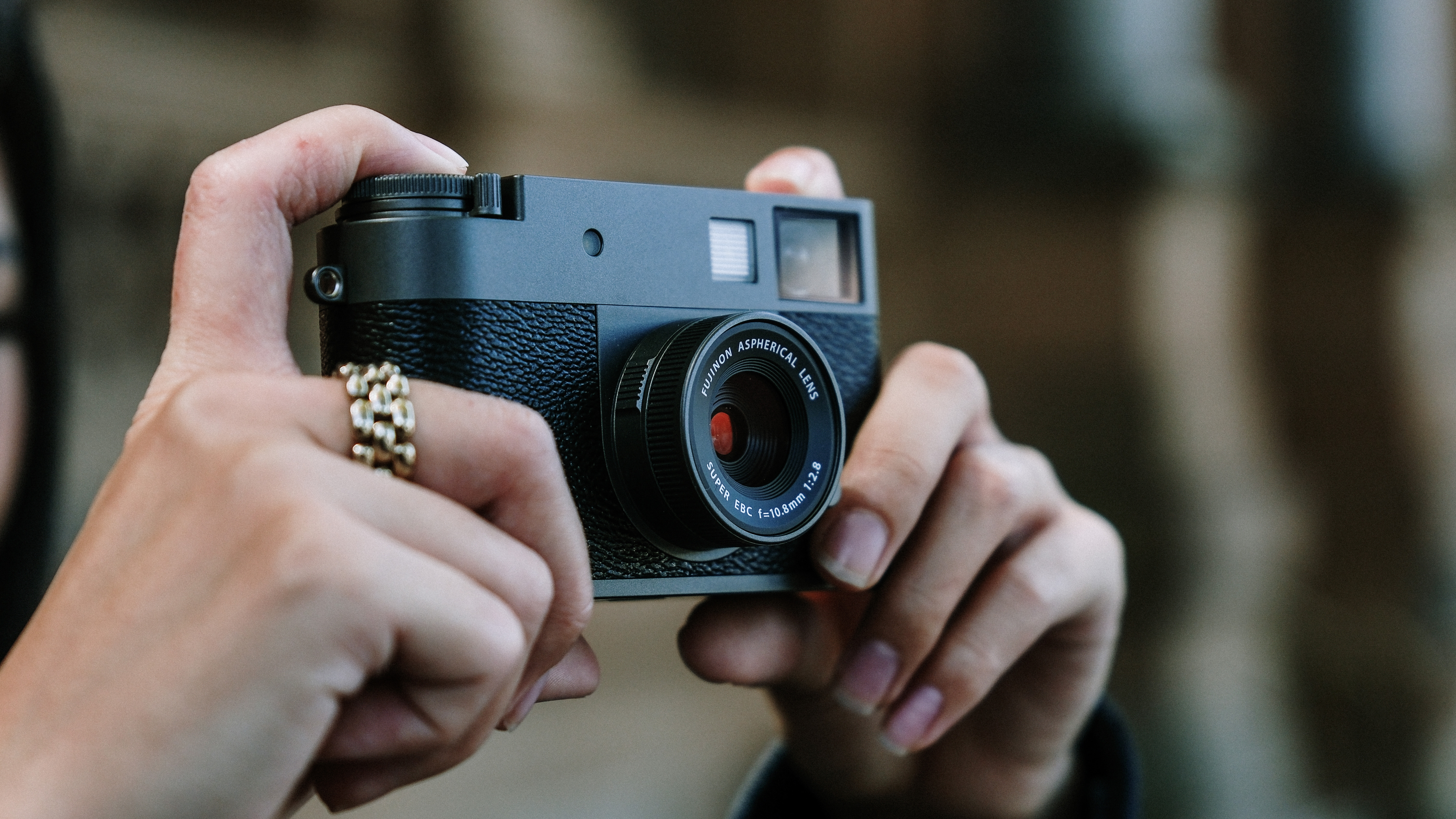 Fujfilm X Half camera held in a pair of hands
