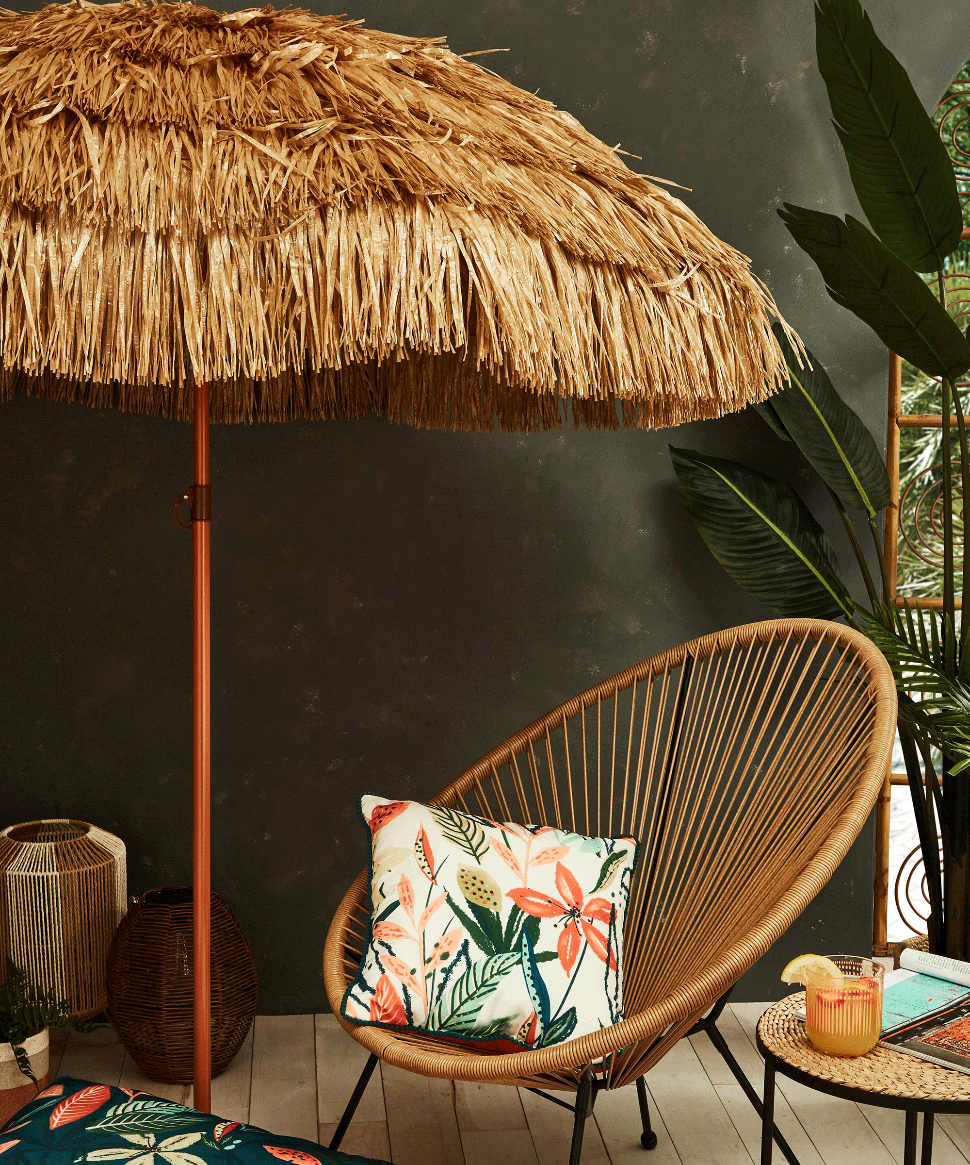 A garden parasol made from synthetic faux grass material with string outdoor chair furniture decor and outdoor cushions