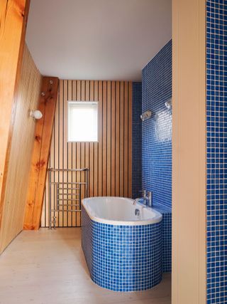 bathroom with internal timber cladding and blue mosaic tiles
