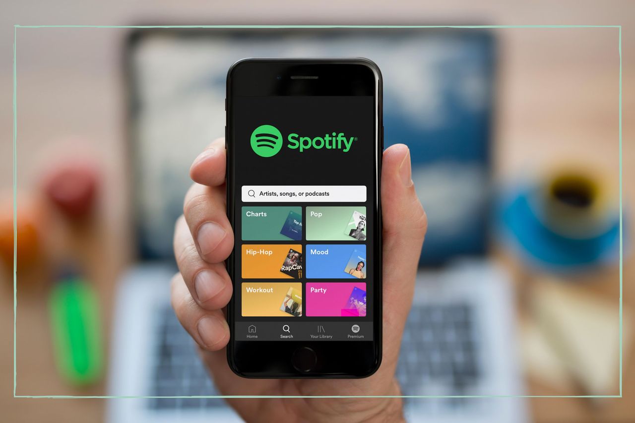 A phone held up with the Spotify app open on the screen