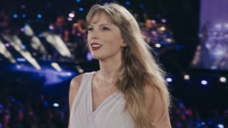 Taylor Swift smiling toward the crowd during the Eras Tour.