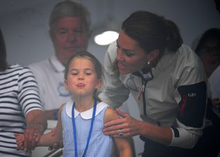 Princess Charlotte sticks out her tongue with mom Kate Middleton behind her