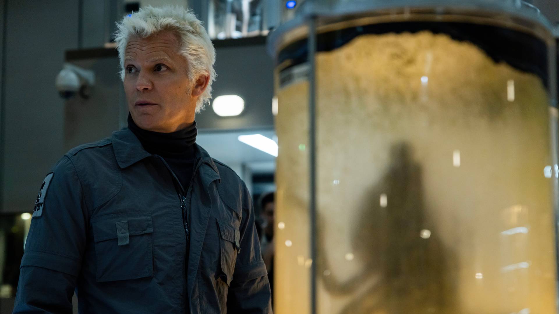 Timothy Olyphant as Kirsh in Alien: Earth, standing in front of a container with an alien specimen inside