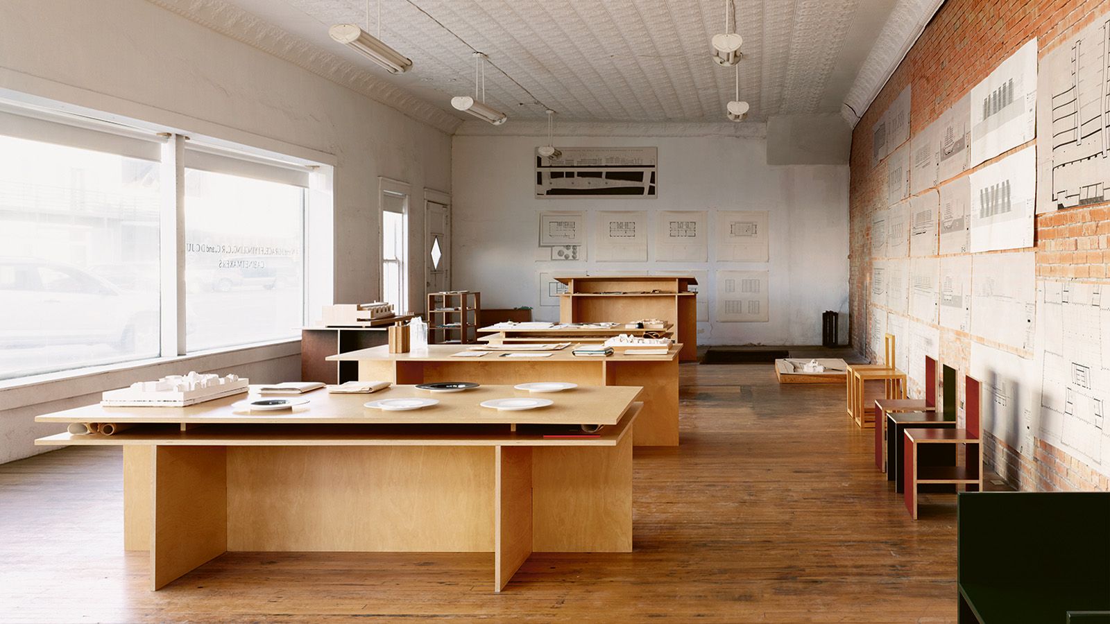 Studio with wooden tables, and sketches on walls