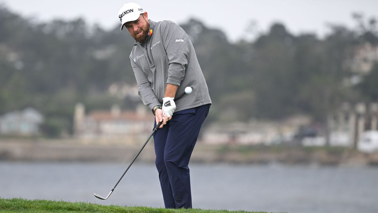 Shane Lowry hitting a chip shot from the side of a green