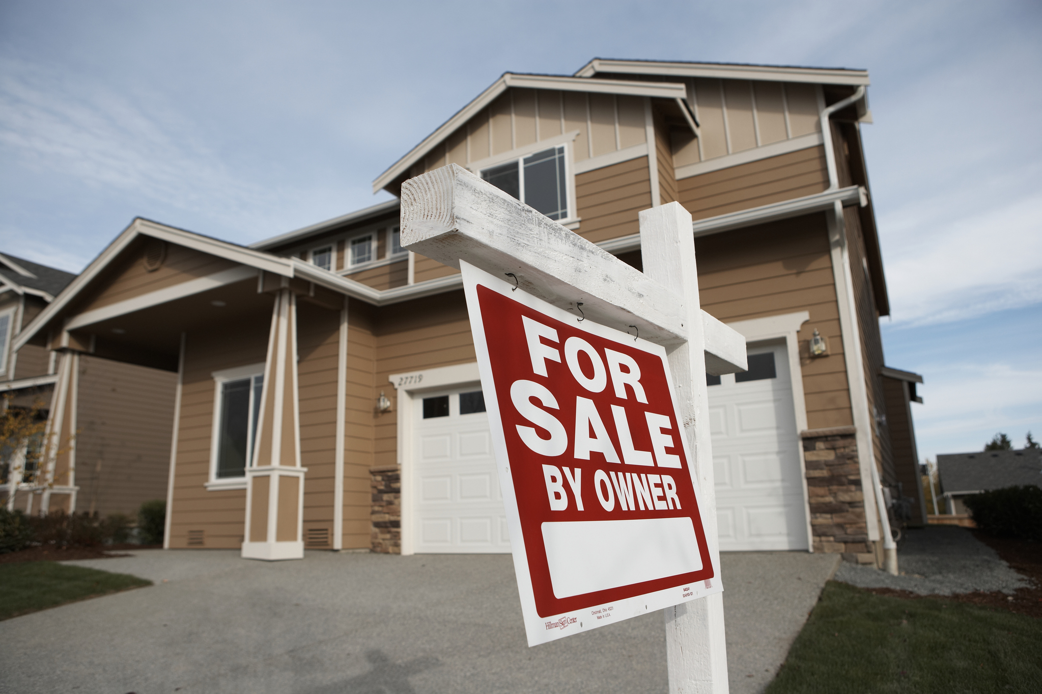 'For Sale' sign in front of house