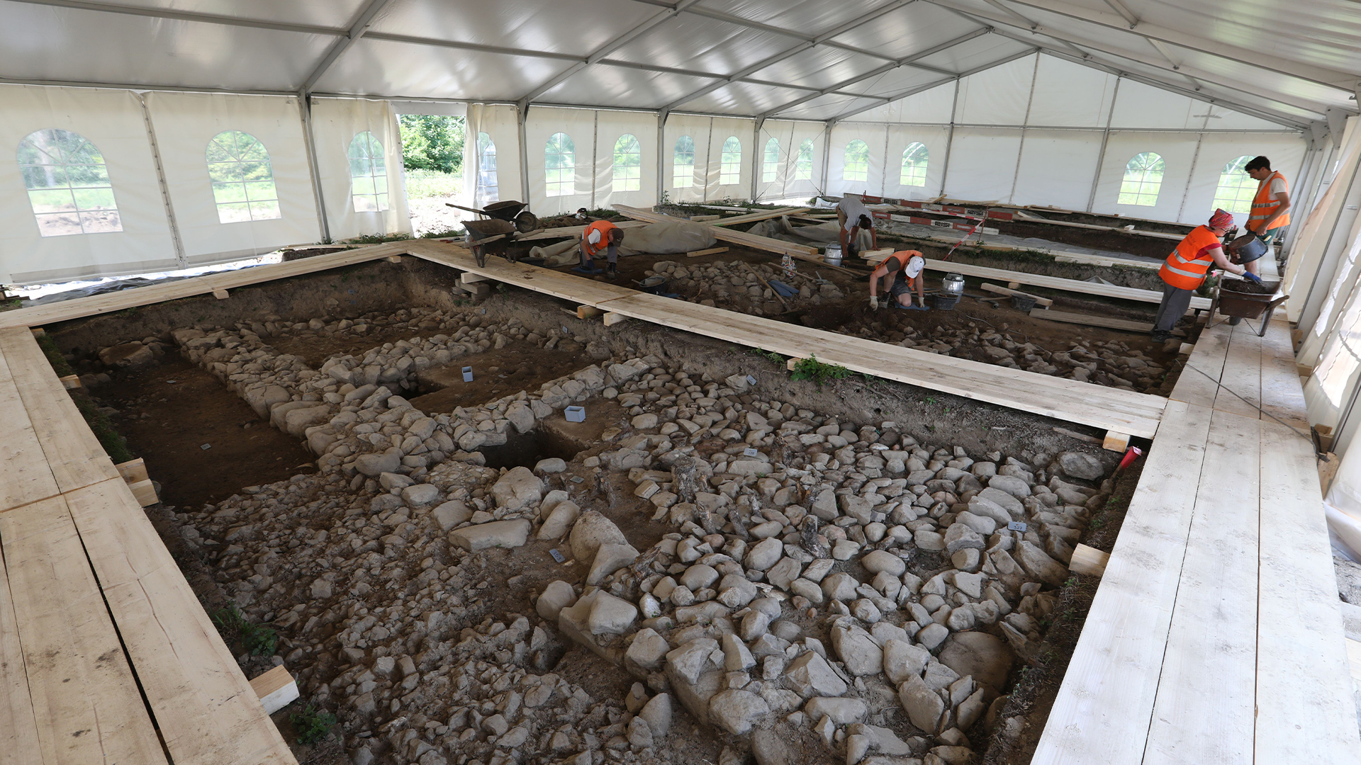 Excavated part of the exposed walls at the Cham-Äbnetwald archaeological site under a tent.
