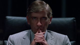 David Warner sits while tenting his hands in thought in Tron.