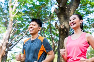 Man and woman running in a park.