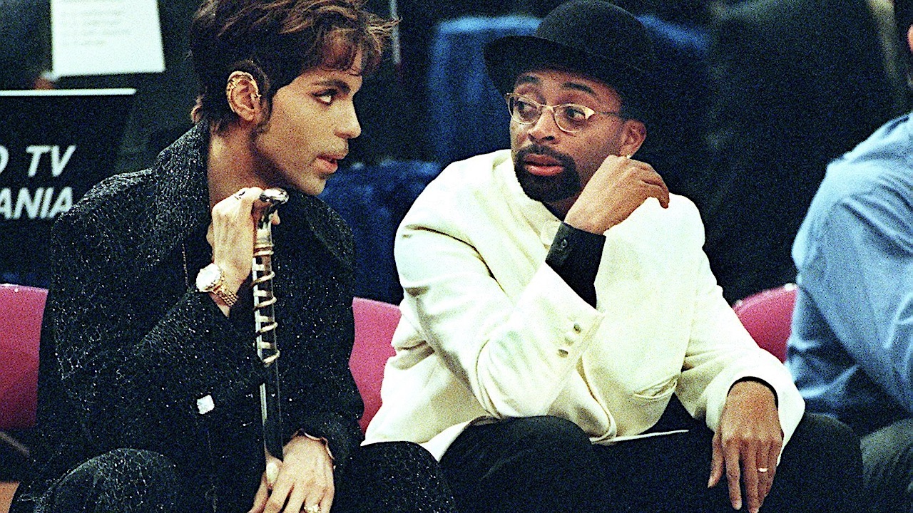 Filmmaker Spike Lee (R), a New York Knicks season ticket-holder, talks with the musician formerly known as Prince (L) during the NBA All-Star Game at Madison Square Garden 08 February. The Eastern Conference All-Stars beat the Western Conference 135-114. AFP PHOTO/Tim CLARY (Photo by Timothy A. CLARY / AFP) (Photo credit should read TIMOTHY A. CLARY/AFP via Getty Images)