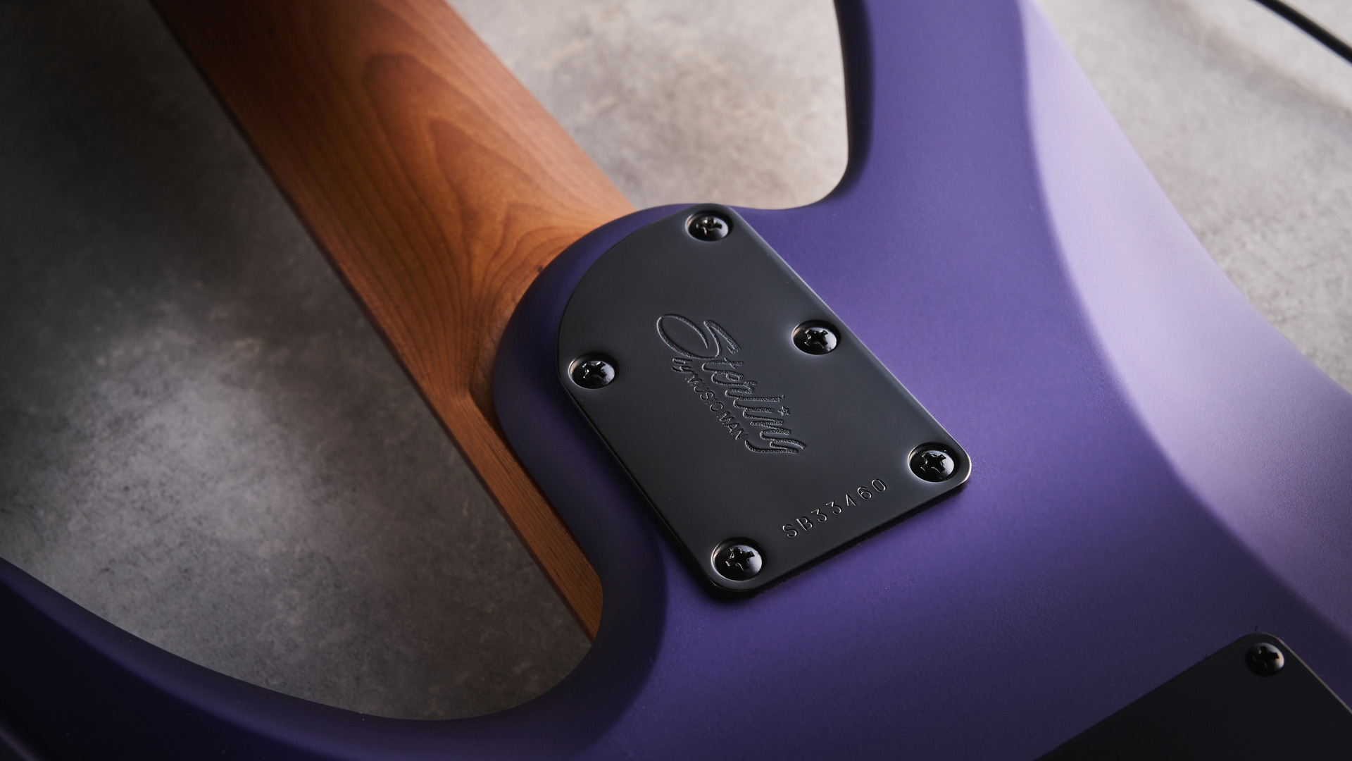 Sterling By Music Man Kaizen 7-string in Firemist Purple Satin, shot in close-up.
