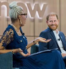 Prince Harry talking to Tessy Ojo of the Diana Award on a blue sofa