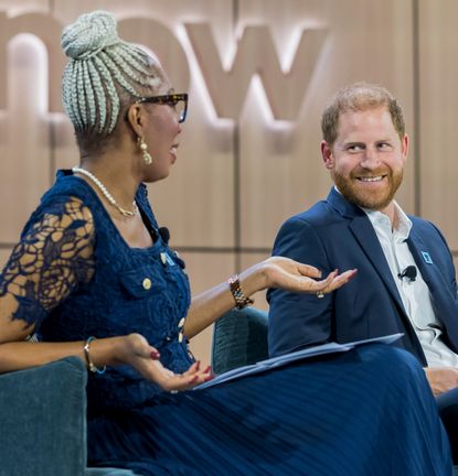 Prince Harry talking to Tessy Ojo of the Diana Award on a blue sofa