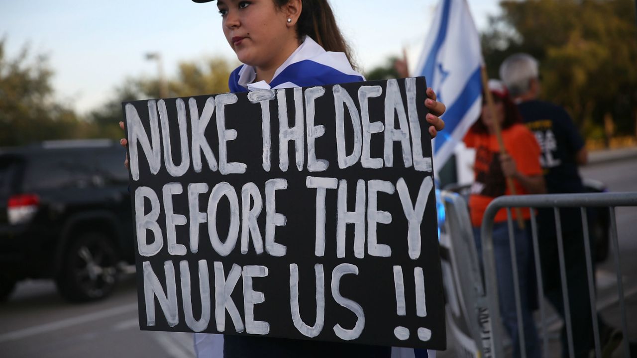 A demonstrator holds a sign calling for the US to &amp;quot;nuke&amp;quot; Iran before it can take nuclear action against the US.