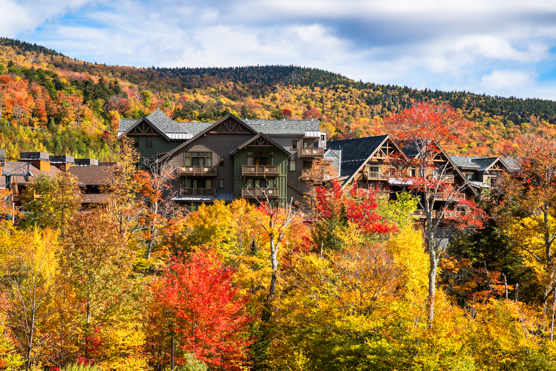 Stowe, Vermont holiday apartment building among colourful maple trees in a mountain landscape in autumn