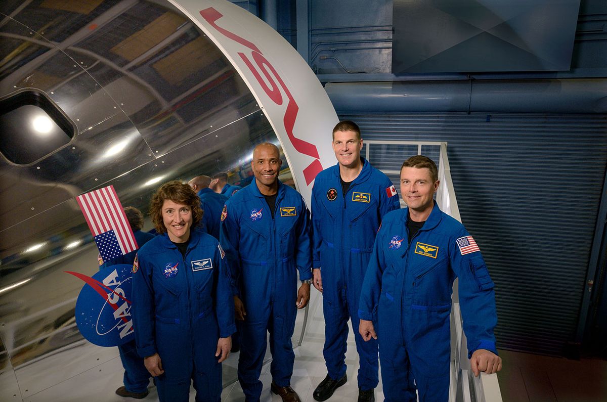 Artemis II crew members (from left) Christina Koch, Victor Glover, Jeremy Hansen and Reid Wiseman pose by an Orion spacecraft simulator at NASA&#039;s Johnson Space Center.