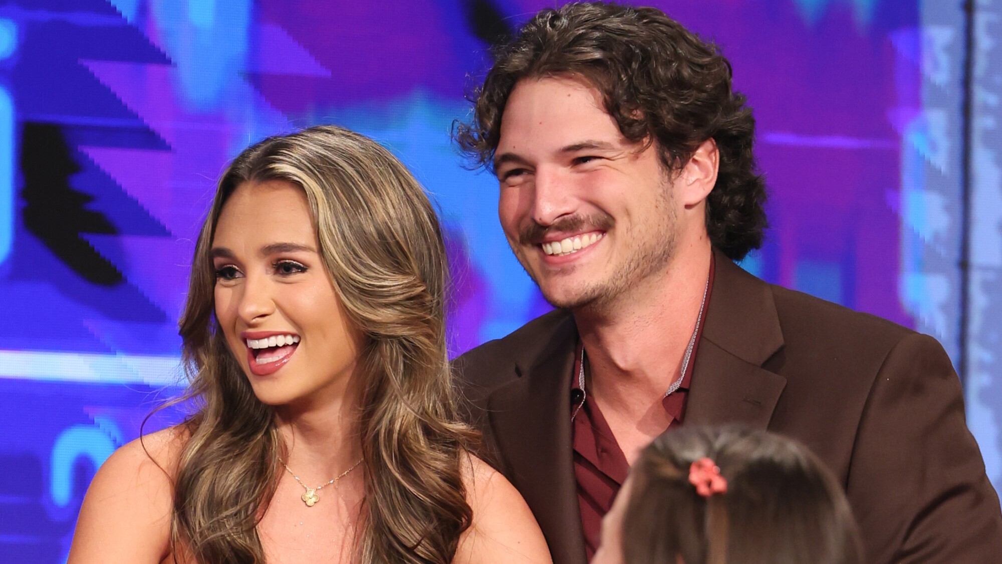 Lyric and Rome on the Big Brother stage on finale night. Both are smiling and talking about their plans to think about moving in together. 