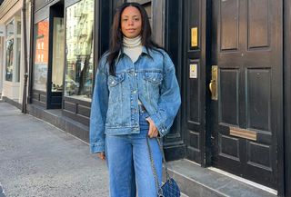 Sierra mayhew is wearing a white turtleneck, denim jacket, jeans and chain handbag.