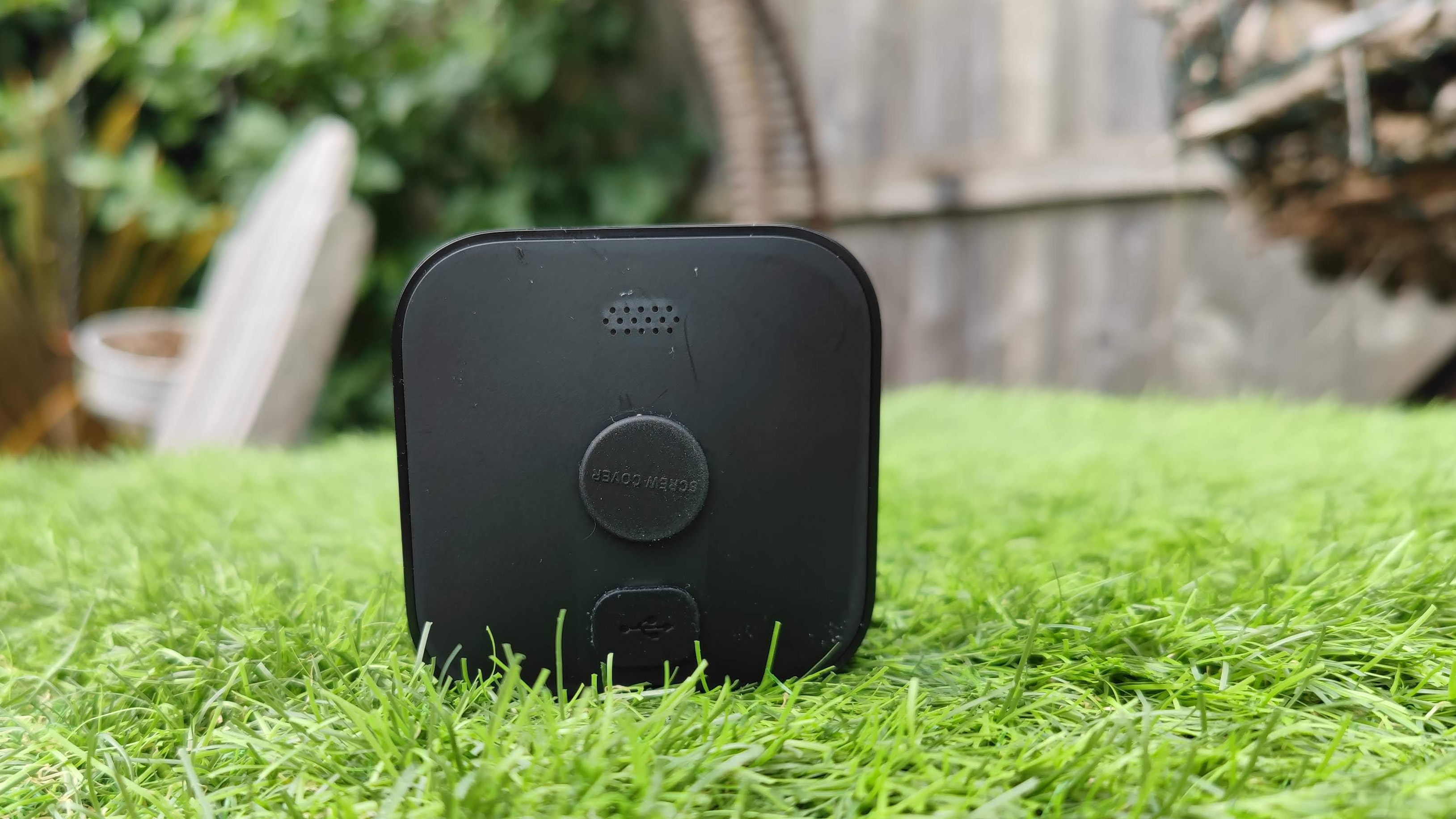 The back of the Blink Outdoor security camera in a garden